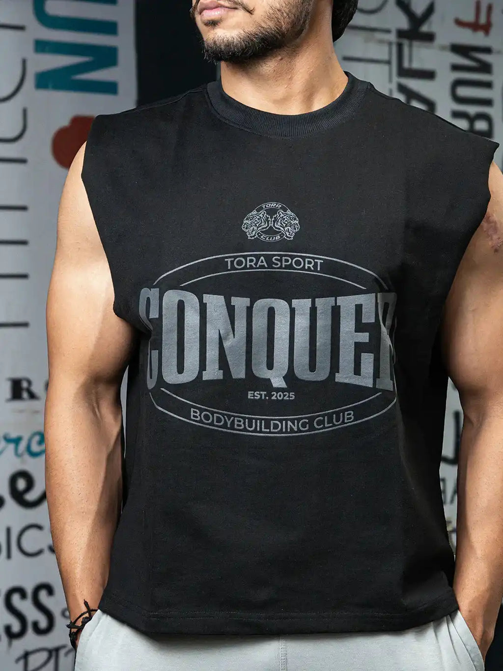 Man wearing black sleeveless gym shirt with 'Conquer Bodybuilding Club' graphic print