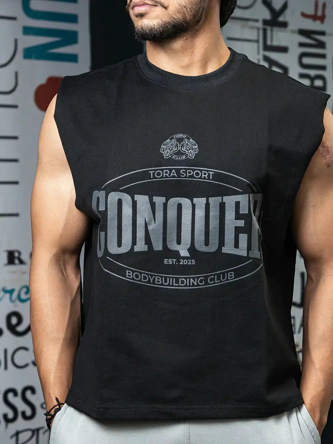 Man wearing black sleeveless gym shirt with 'Conquer Bodybuilding Club' graphic print