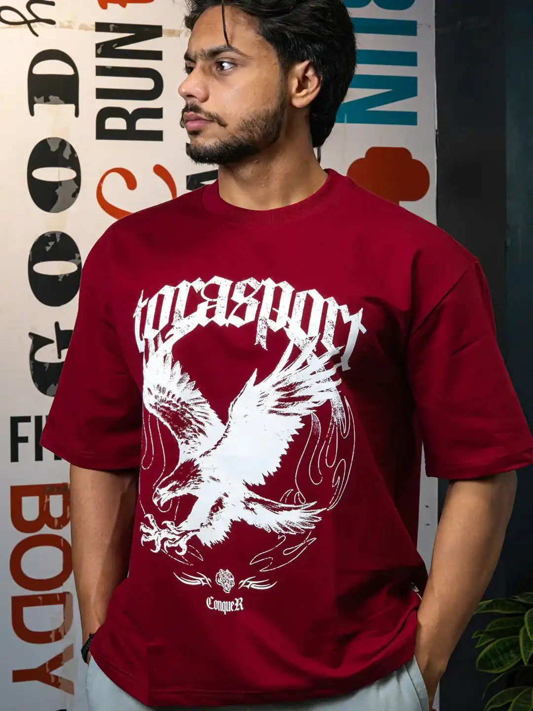 Man wearing maroon graphic gym t-shirt with bold white eagle and lettering design