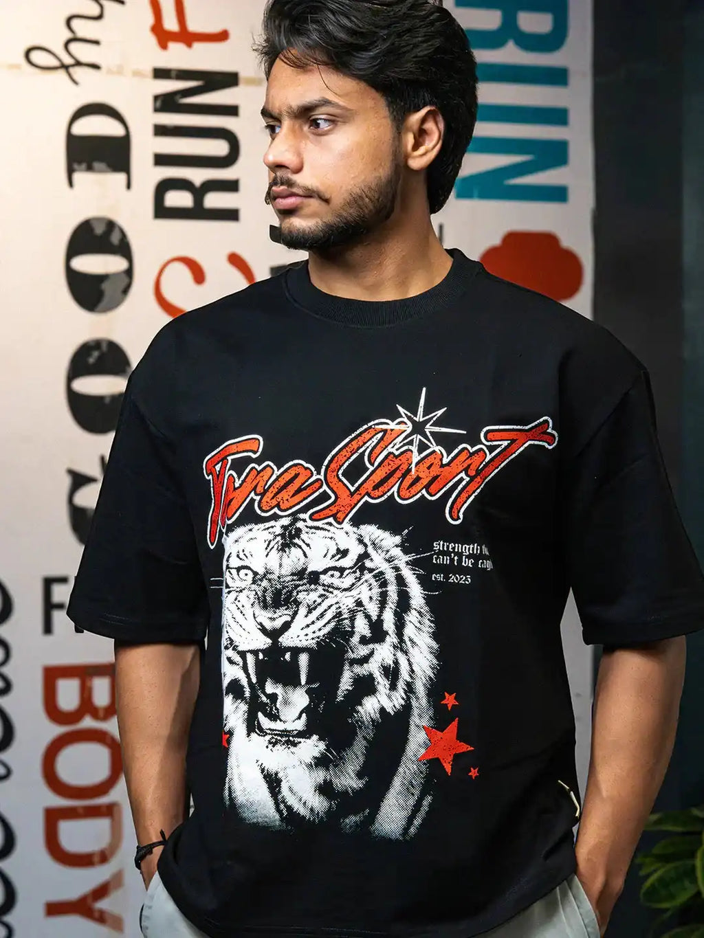 Man wearing black gym t-shirt with bold roaring tiger graphic and motivational text