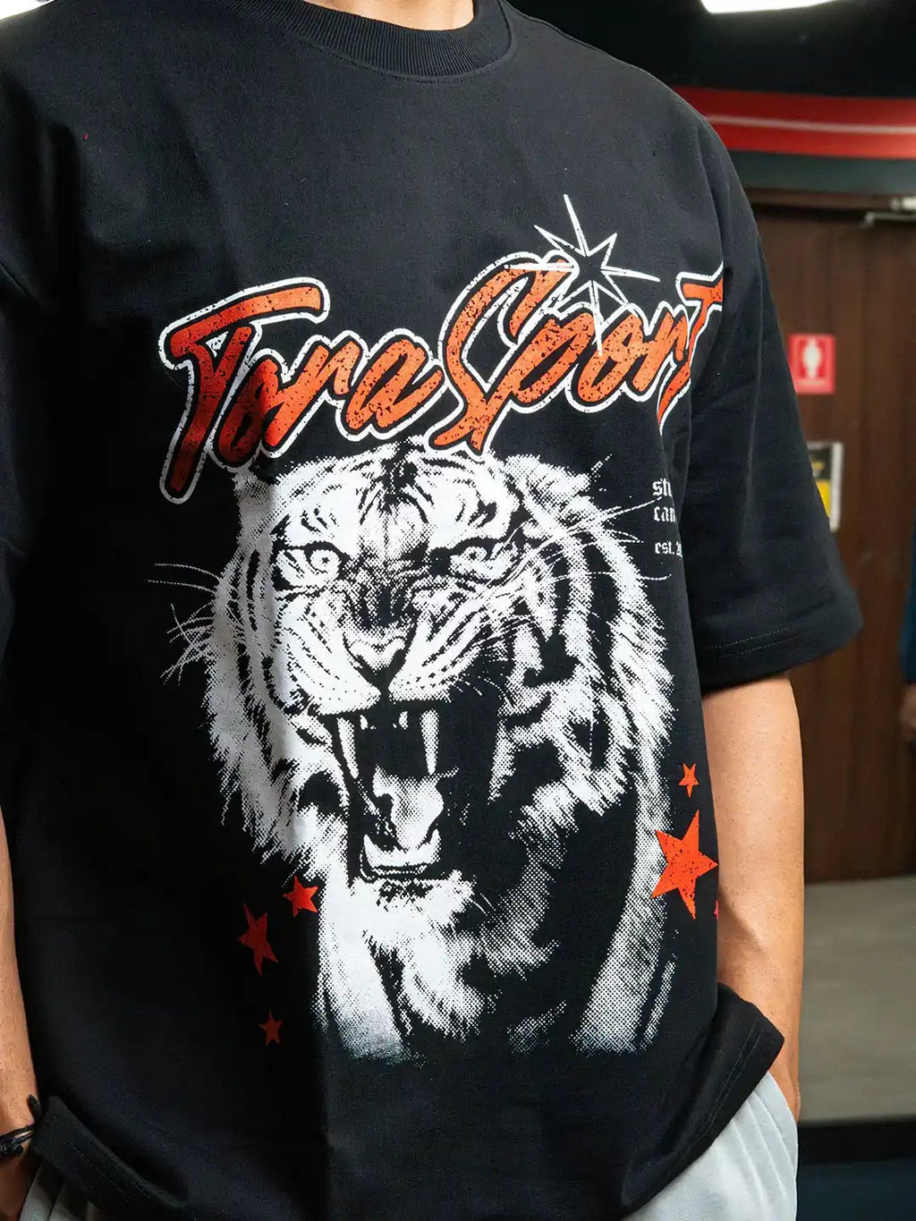 Black gym t-shirt with roaring tiger graphic and bold athletic lettering, lifestyle wear